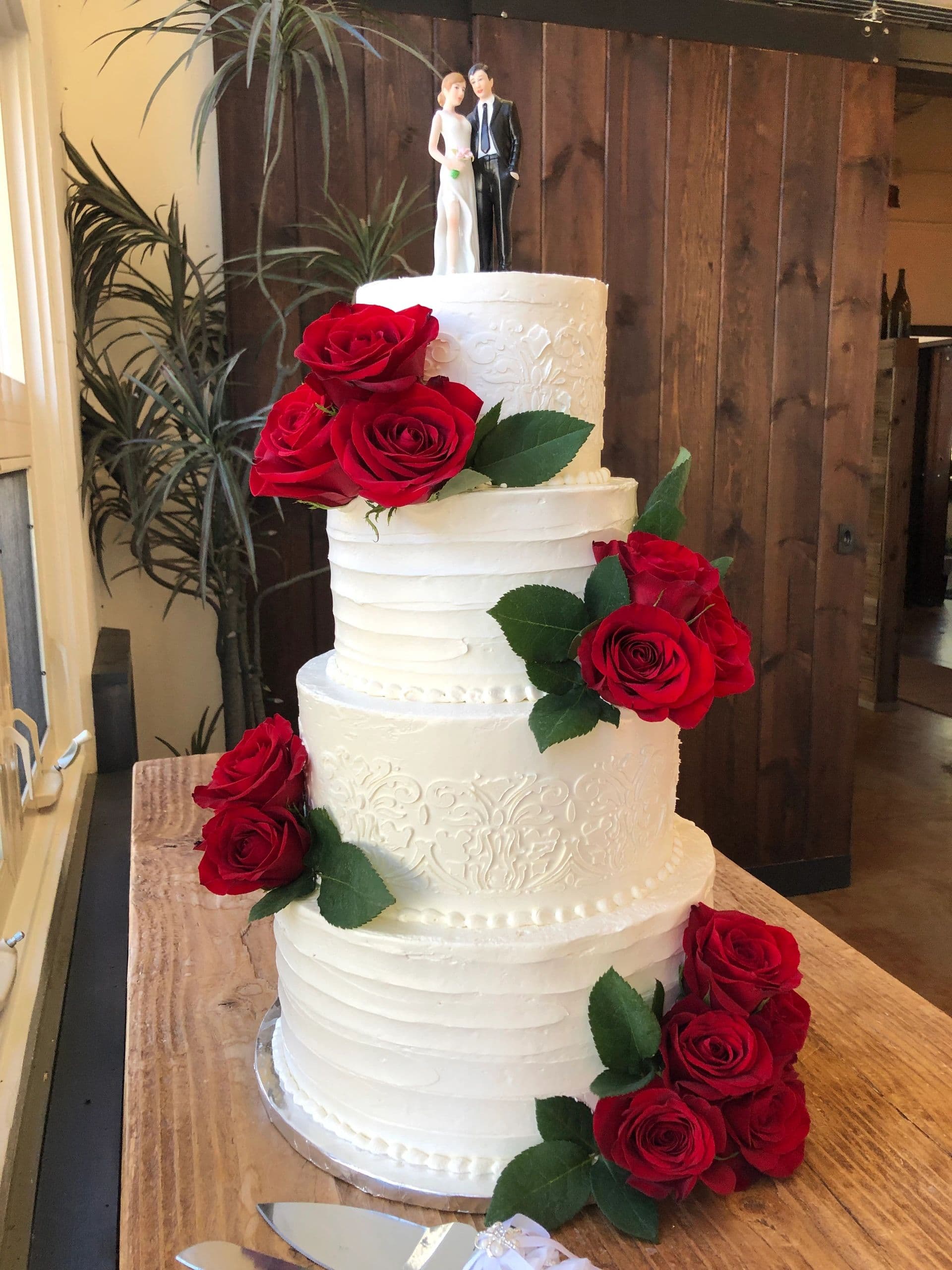 White four-tier wedding cake with red roses